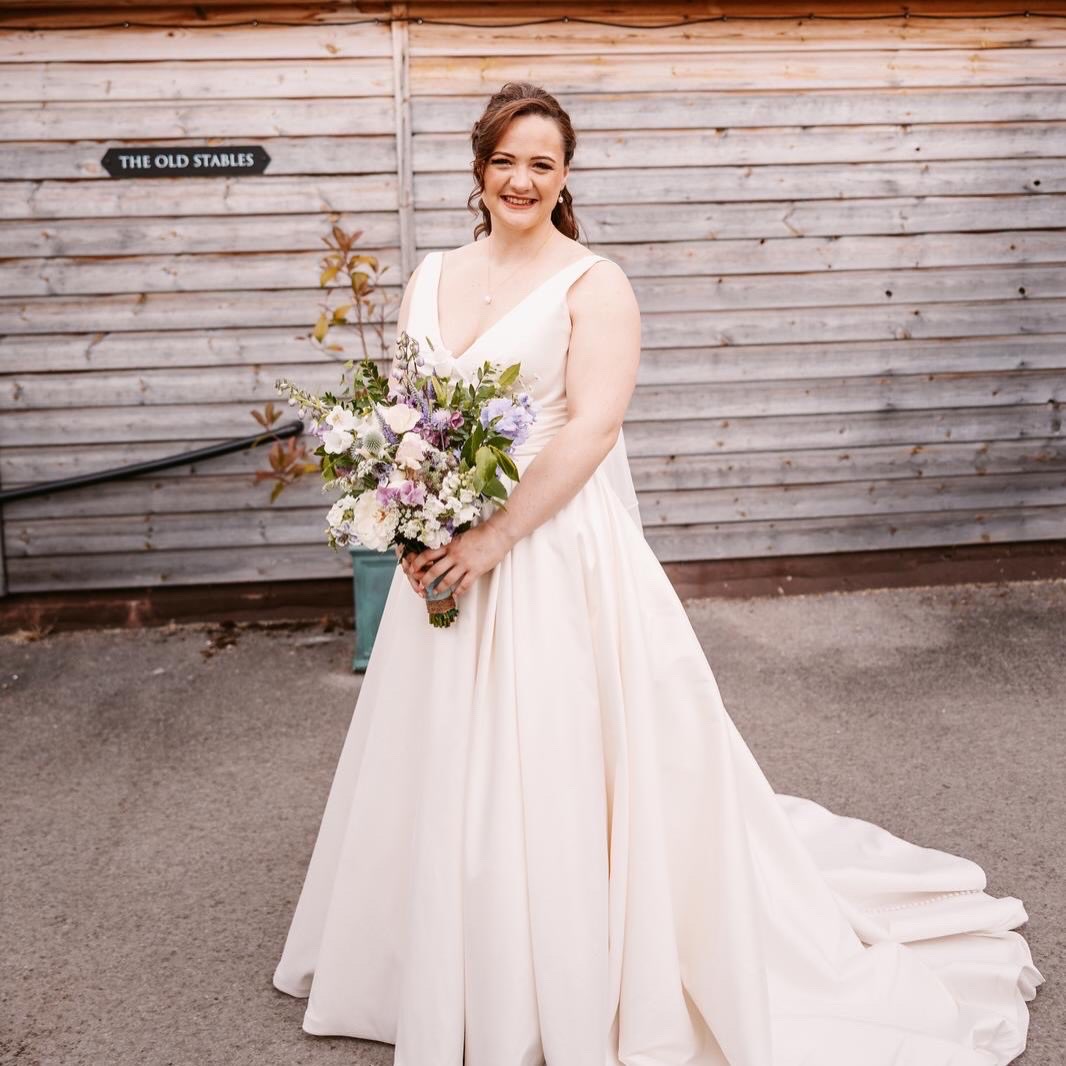 Bride in a gown holding flowers outdoors