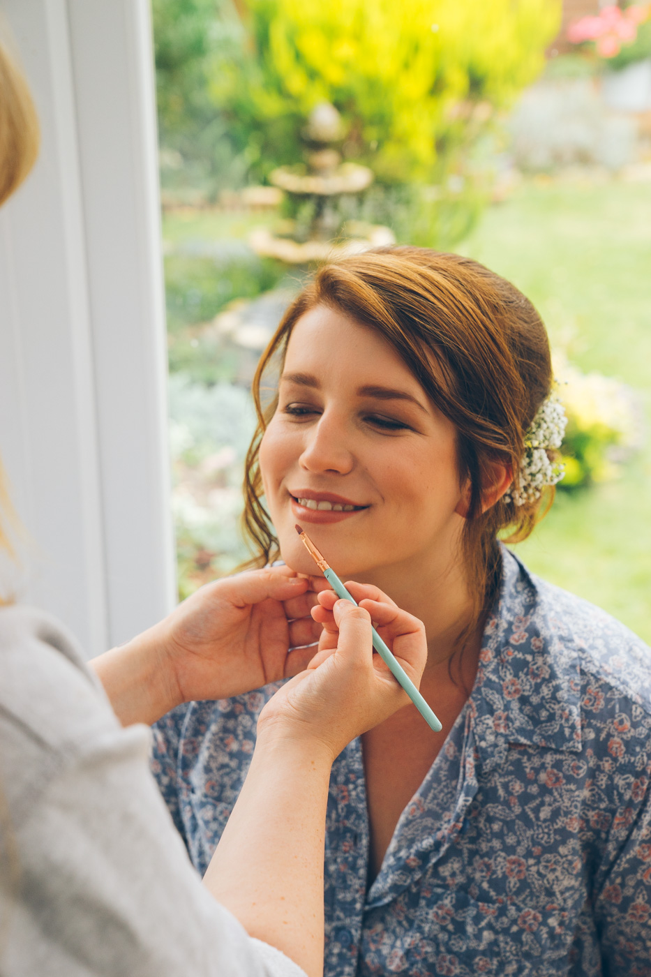 Laura applying makeup to a bride on her wedding morning